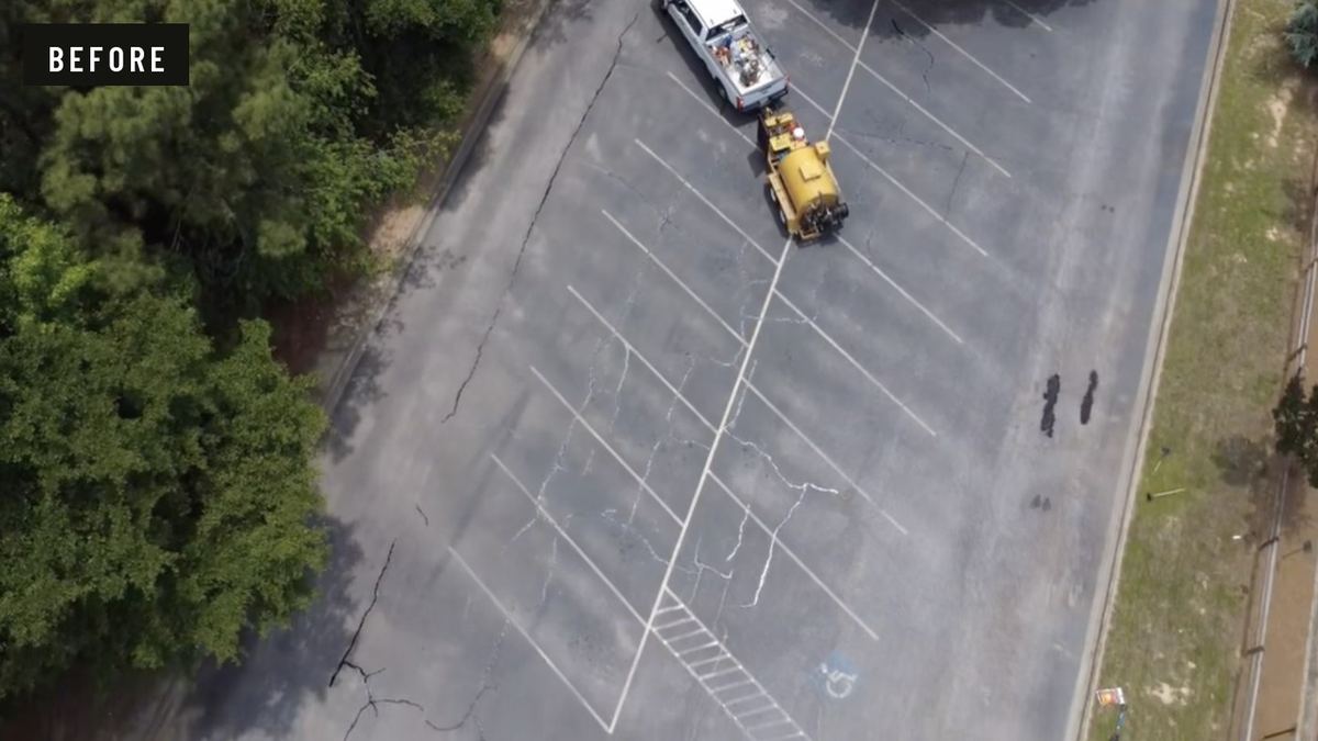 Before: overhead view of a grey parking lot with long branching cracks running across the stalls.